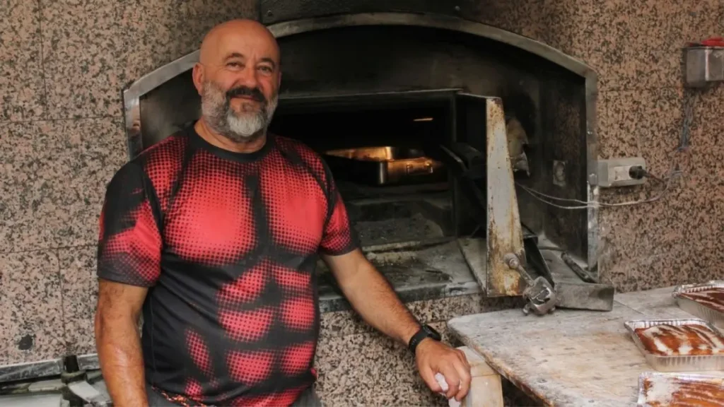 Nené, baker at Panadería Escairón, standing by his wood-fired oven